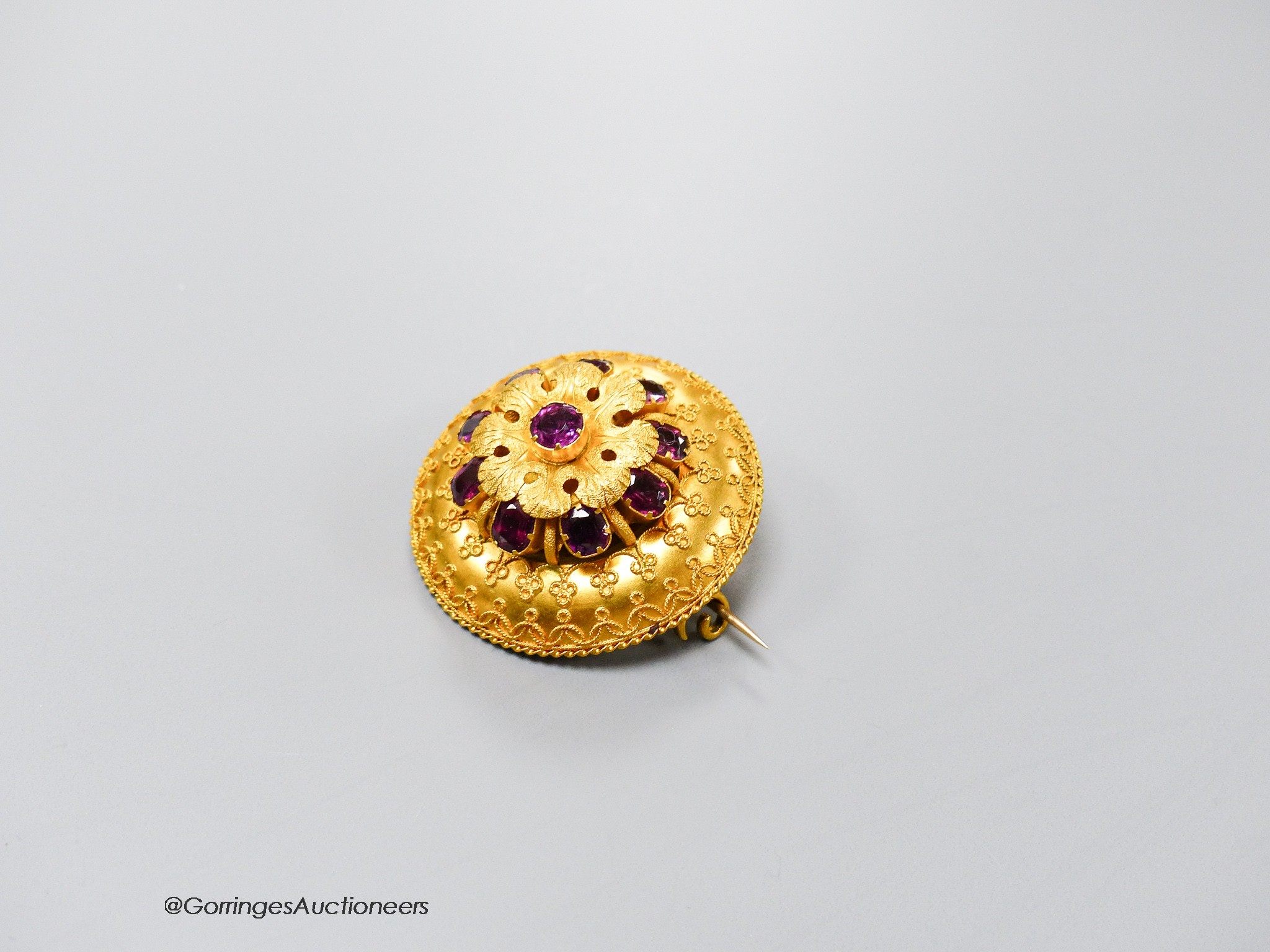 A Victorian yellow metal and ten stone garnet set cannetile work circular brooch, 39mm, gross 17.9 grams.